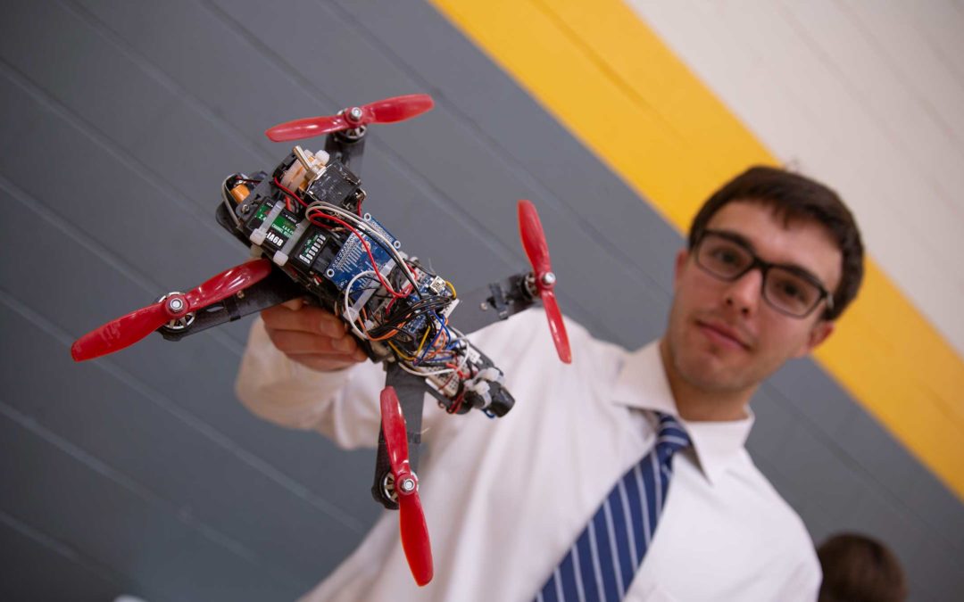 A student holds a drone for the camera in ASU's Drone Studio